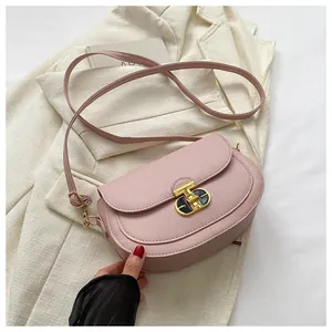 Detail of light pink saddle bag with lychee texture and unique metal clasp design