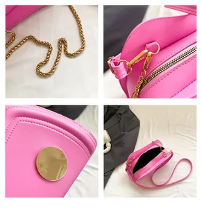 Detailansicht der pinkfarbenen Umhängetasche mit goldener Kette und Metallbeschlägen