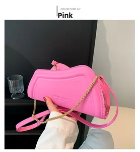 Nahaufnahme einer rosa wellenförmigen Tasche mit goldener Kette und Leder-Oberfläche