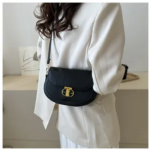Close-up of black Saffiano leather saddle bag with distinctive gold metal buckle