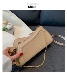 Khakifarbene Leder-Schultertasche mit Goldkette auf Sofa mit Tulpen-Detail