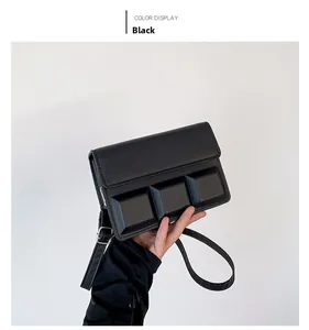 Detail van een zwarte crossbodytas met gewatteerde flap en zilverkleurige metalen accenten