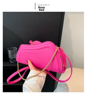 Detailansicht der rosaroten Ledertasche mit goldener Kette und geprägtem Modelogo