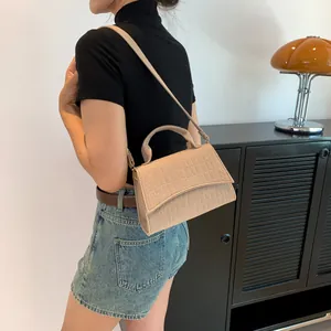 Beige crocodile embossed felt crossbody bag with top handle and fine shoulder strap