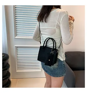 Détail du sac bandoulière noir en feutre matelassé avec pochette et anses rondes
