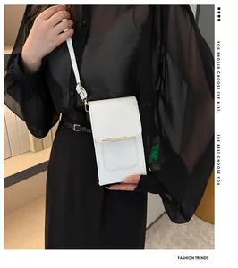 Chic white leather crossbody phone bag shown with gold trim on a fashion model