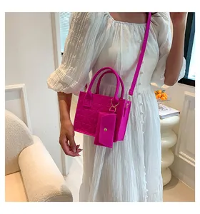 Détail du sac à main rose gaufré avec mini pochette et poignées cylindriques