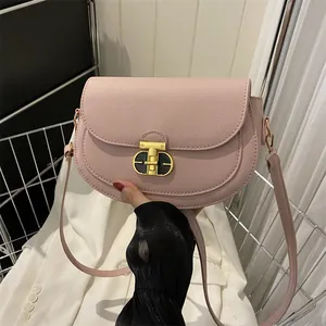 Pink faux leather saddle bag with gold metal clasp and crossbody strap for women