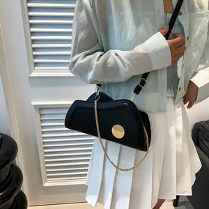 Klassische schwarze Leder-Schultertasche mit goldener Kette und rundem Metall-Emblem