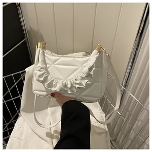 Detail der weißen gesteppten Tote-Bag mit geometrischem Muster und gerafftem Griff