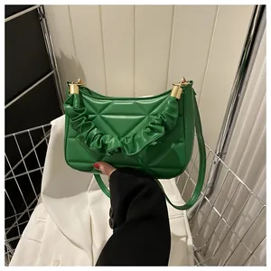 Detailansicht der grünen Stepptasche mit raffiniertem Raffgriff und goldenen Metallteilen