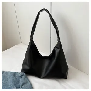 Detail shot of the minimalist black hobo bag showing its smooth texture and zipper