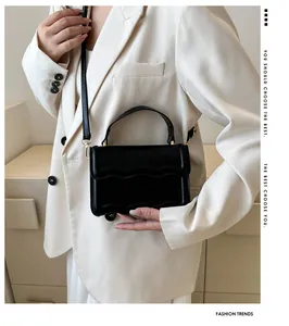 Close-up of black PU leather bag featuring scalloped edge design and gold metal hardware