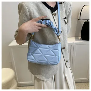 Nahaufnahme der hellblauen Stepptasche mit gerüschtem Griff und goldenem Metallring