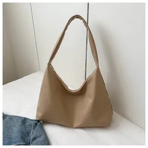 Detailed view of camel faux leather crescent shoulder bag with seamless wide strap