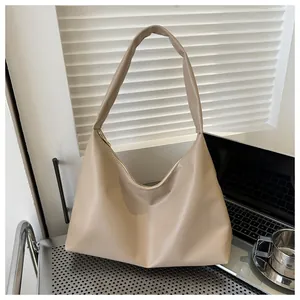 Close-up of beige faux leather tote bag showing smooth texture and metal zipper detail
