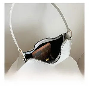 Internal view of the white faux leather baguette bag showing storage space for cosmetics