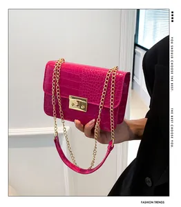 Detail of rose pink crocodile pattern handbag with gold chain strap and square buckle