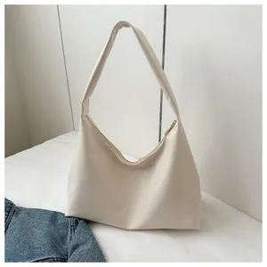 Minimalist hobo shoulder bag in cream white with wide strap and metallic zipper closure