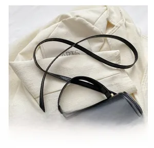Detail of black wave-flap crossbody bag featuring matte leather and gold hardware