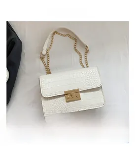 Detail of white crocodile pattern shoulder bag with gold square buckle and chain strap