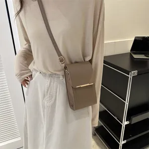 Brown faux leather mini crossbody phone bag with gold metal trim and adjustable strap
