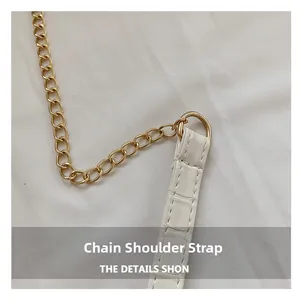 Detail of white crocodile pattern leather strap with light gold metal chain link