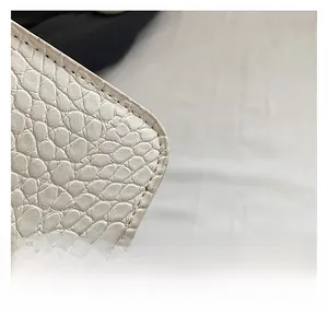 Close-up of beige crocodile pattern leather texture with precise stitching detail