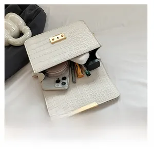 Interior view of white crocodile pattern bag showing capacity for phone and cosmetics