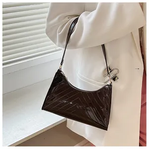 Detailed view of the wavy quilted glossy dark coffee shoulder bag with metallic buckle