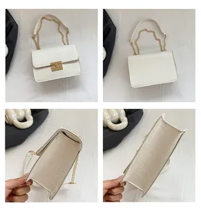 Macro views of white faux crocodile leather handbag with gold chain strap and square buckle
