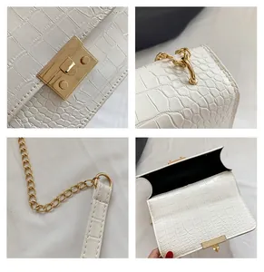 Macro detail of white crocodile texture leather and golden metal chain buckle for handbag