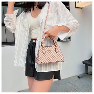 Detailed view of light pink trapezoid handbag with brown geometric dots and gold hardware