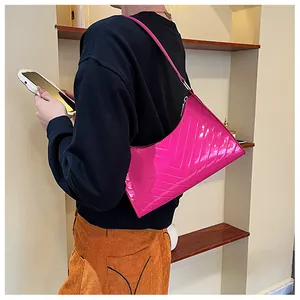 Detail of fuchsia patent leather underarm bag featuring a stylish V-shaped quilted pattern