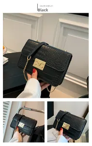 Detailed macro view of black crocodile pattern leather bag with golden metal clasp