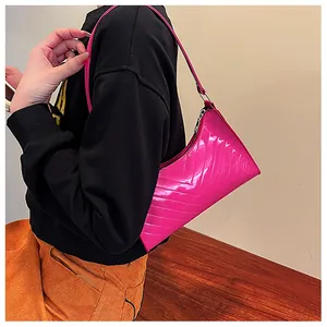 Detail of fuchsia glossy patent leather underarm bag with stylish V-shaped quilting