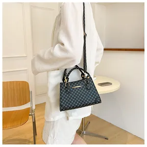 Detailed view of the dark geometric pattern tote bag with gold metal handle and slim strap
