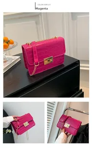 Close-up of rose red faux leather chain bag with crocodile texture and gold hardware