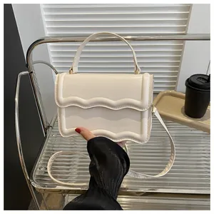 Close-up of beige square bag featuring a stylish wavy flap edge and smooth PU leather