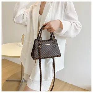 Detail of vintage geometric pattern shoulder bag with golden hardware and handles