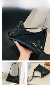 Close-up of black glossy patent leather handbag with elegant V-shaped quilting detail