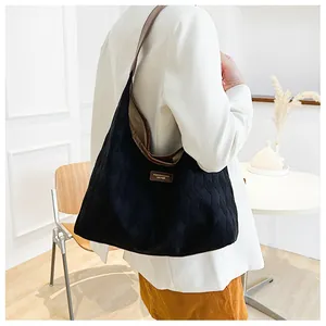 Détail d'un grand sac cabas matelassé noir en toile avec finitions en cuir marron