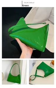 Detail of green patent leather underarm bag with V-shaped quilting and glossy finish