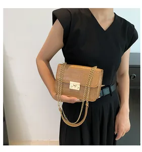 Detail of caramel brown croc-embossed shoulder bag with gold metal buckle and chain strap