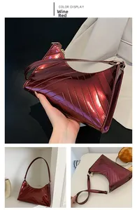 Macro view of wine red glossy patent leather shoulder bag with V-quilted stitching detail
