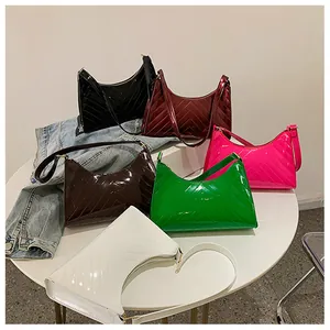 Detail showing various colors of glossy patent leather underarm bags with V-shaped quilting