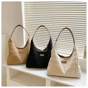Détail de sacs cabas en toile matelassée kaki et noir avec anses en cuir