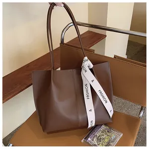Detail of a dark brown vintage tote bag made of high-quality faux leather on a leather chair