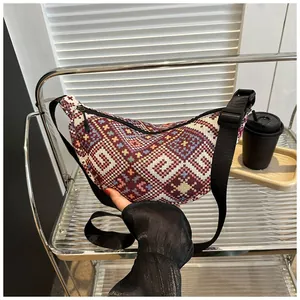 Detailed close-up of bohemian woolen crescent bag with colorful woven geometric patterns