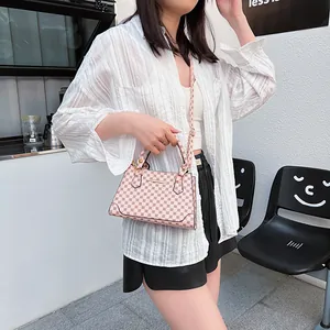 Pink vintage patterned handbag with shoulder strap for women shown in a street style view